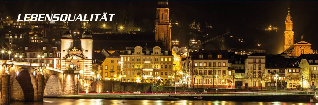 Eine am Fluss gelegene, beleuchtete Altstadt bei Nacht. | © SCHUCH