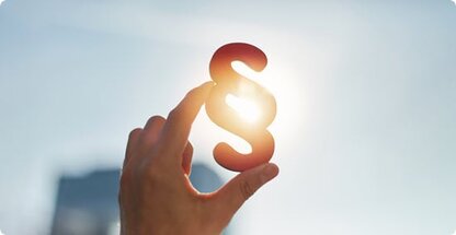 Paragraph Zeichen wird mit einer Hand vor die Sonne gehalten