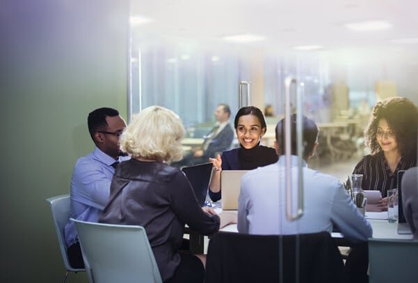 Ein Team bespricht sich in einem Besprechungsraum in einer Büroetage.